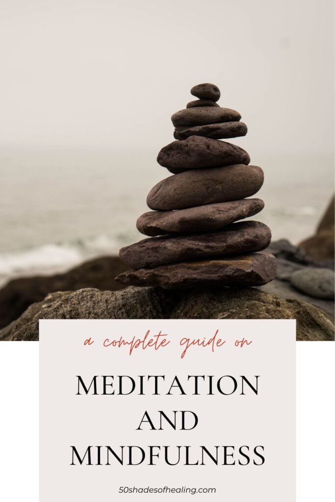 A stack of balanced stones by the sea with text reading, "A complete guide on Meditation and Mindfulness," and website 50shadesofhealing.com to explore the depths of mindfulness.