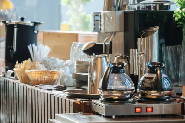 Coffee Station Goals: How to Create a Café Vibe at Home 4 Coffee station with two glass coffee pots, a coffee maker, tea kettle, cups, utensils, and a basket of stir sticks on a counter—perfect for bringing that cozy café vibe into your home or energizing your restaurant.
