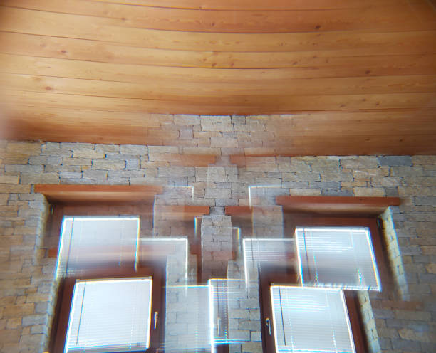 Blurred image of a stone wall with two windows and a wooden ceiling, showing a distorted, double-vision effect&mdash;perfect inspiration for a gratitude wall or unique home decor accent.